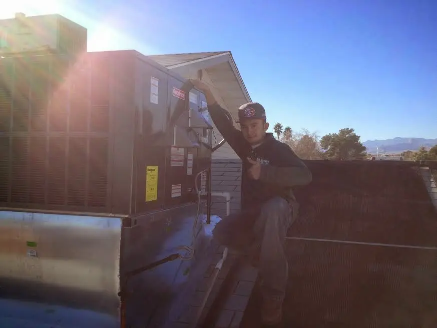 HVAC technician performing Air Duct Repair on a rooftop unit in Seymour
